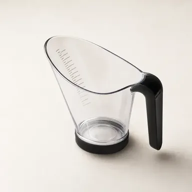 Angled measuring cup filled with oil, showing the measurement markings read from above