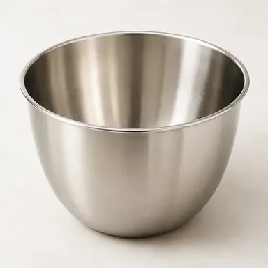 Deep stainless steel mixing bowl on a light surface