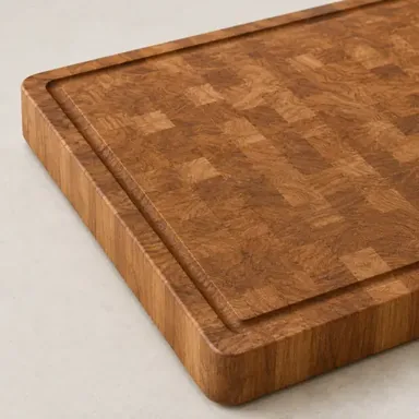 Large wooden cutting board with a juice groove around the edge and a sliced lemon
